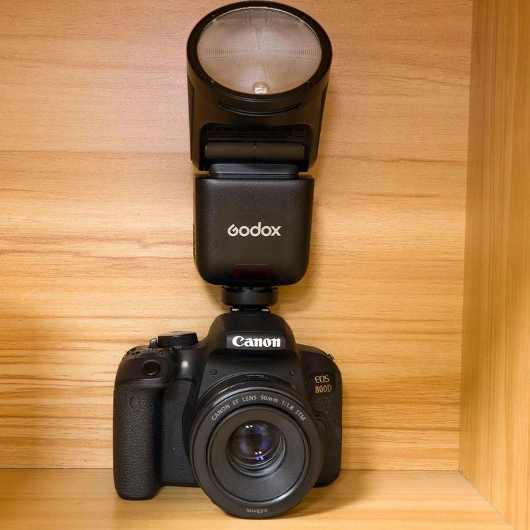 Накамерная вспышка Godox V1 с круглой головкой в вертикальном положении на зеркальной камере Canon EOS 800D